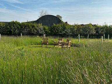 A garden with chairs and a table in the grass at Keepers Cottage in West Knoyle