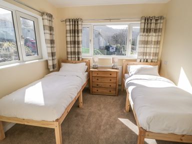 A bedroom with two single beds and a wooden chest of drawers between them at Arwelfa in Penmaenmawr