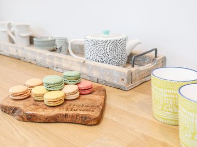 Macarons on a wooden board with teapot and cups on a table at Ty ar Ben Bryn in Pencarnisiog near Rhosneigr
