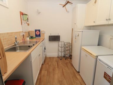 A utility room with a sink washing machine fridge and freezer at Changing Tide in Beadnell