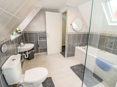 A bathroom with a toilet sink bathtub and tiled walls at Station View in Whitby