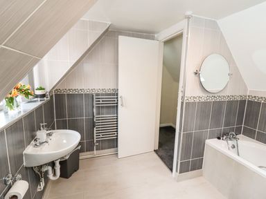 A bathroom with a sink mirror bathtub and towel rack at Station View in Whitby