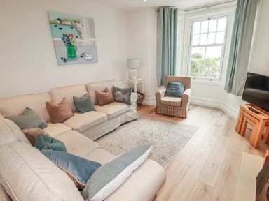 A living room with furniture and decor at Beachcomber in Padstow