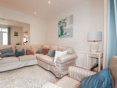 A living room with a sofa and lamp at Beachcomber in Padstow