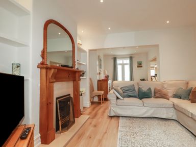 A living room with a sofa and a fireplace at Beachcomber in Padstow