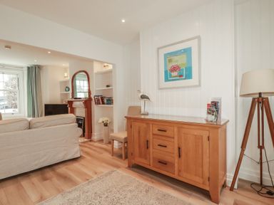 A living room with a cabinet and lamp at Beachcomber in Padstow