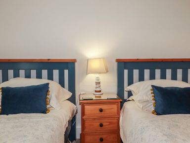 A bedroom with two beds and a nightstand at Beachcomber in Padstow