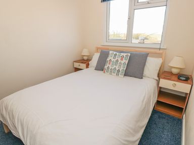 A bedroom with a bed and bedside tables under a window at 304 Norton Park in Dartmouth