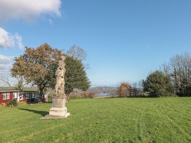 A lawn with a statue on a pedestal surrounded by trees and a building in the background at 304 Norton Park Dartmouth