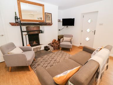 A living room with armchairs sofa fireplace and a wall-mounted television at Kealduff Lower in Glenbeigh County Kerry