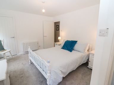 A bedroom with a double bed two bedside tables a chair and a radiator at Kealduff Lower in Glenbeigh County Kerry