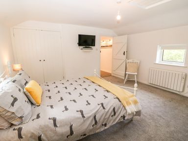 A bedroom with a bed a chair a television and a radiator at Kealduff Lower in Glenbeigh County Kerry