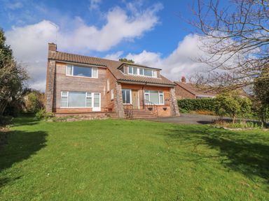 A detached house with a tiled roof and large front lawn at Casalmare in Exmouth