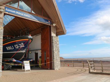 A lifeboat inside the Exmouth lifeboat station with a view of the beach and sea at Casalmare in Exmouth