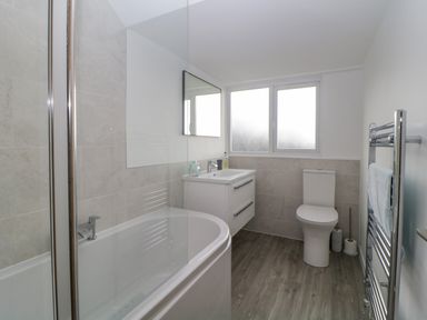 A bathroom with a bathtub shower sink toilet and towel rack at Casalmare in Exmouth