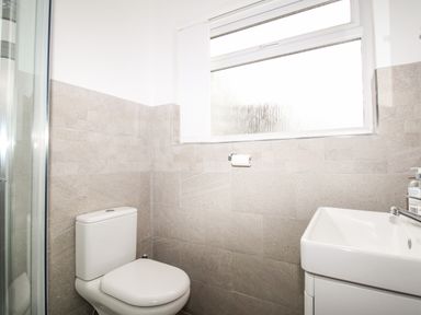 A bathroom with a toilet sink and a window at Rosamond in Shipton Gorge