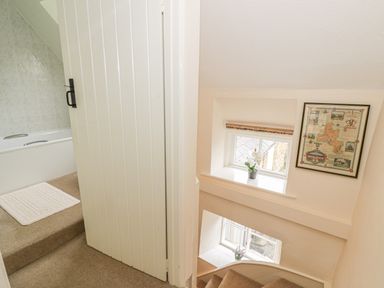 A view of a staircase with windows and a framed map on the wall at Spring Cottage in Alkerton near Banbury