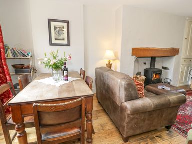 A dining room with a table, chairs, and a sofa at Sygun View in Beddgelert