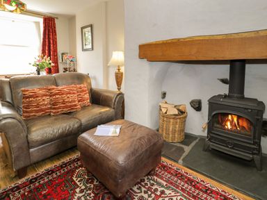 A living room with a sofa and fireplace at Sygun View in Beddgelert