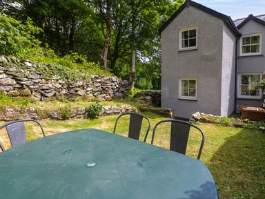 A garden with a table and chairs at Sygun View in Beddgelert