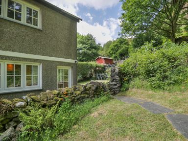 A garden with a house and a red shed at Sygun View in Beddgelert