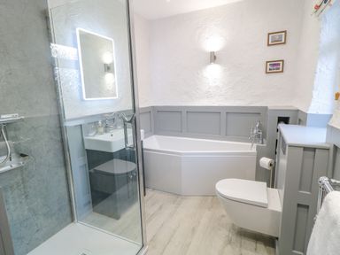 A bathroom with a shower, bathtub, sink, and toilet at Quiet Waters Cottage in Loughan near Coleraine