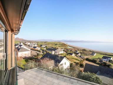 A coastal neighborhood with houses and a beach view from a balcony at Hafod Y Mor in Criccieth