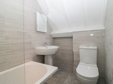 A bathroom with bathtub sink toilet and mirror at The Linhay in Chardstock