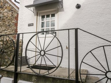 An entrance door with a window and decorative black metal railings at The Linhay in Chardstock