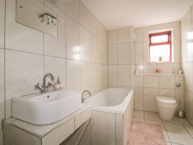 A bathroom with a sink bathtub toilet and a window at Elin Howlyek in Newquay