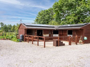 A stable with fencing and a water barrel at Willow Barn in Cucklington near Wincanton