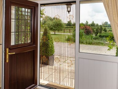 An entrance with a wooden door and beaded curtain at Willow Barn Cucklington near Wincanton
