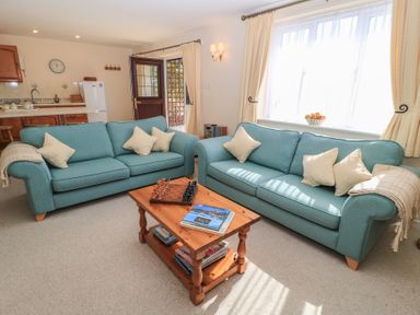 A living room with sofas and a chess set at Willow Barn in Cucklington near Wincanton