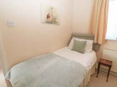 A bedroom with a bed and painting at Willow Barn in Cucklington near Wincanton