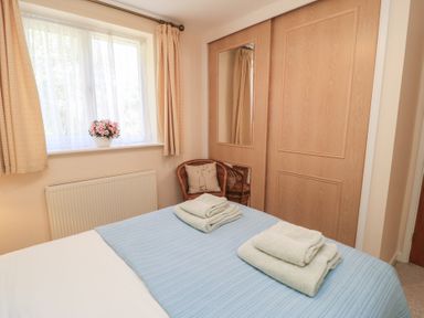 A bedroom with a bed and towels arranged at Willow Barn in Cucklington near Wincanton