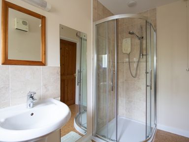 A bathroom with a sink and a glass enclosed shower at Little Barn in Cucklington near Wincanton