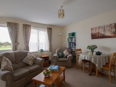A living room with sofa armchair wooden table and dining table with chairs at Little Barn in Cucklington near Wincanton
