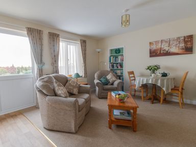 A living room with two armchairs a wooden coffee table and a small dining table with three chairs at Little Barn Cucklington near Wincanton