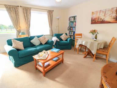 A living room with a sofa and dining table at Little Barn in Cucklington near Wincanton