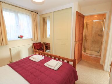 A bedroom with a bed and mirror at Little Barn in Cucklington near Wincanton