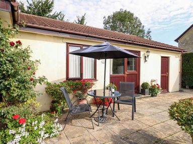 An outdoor seating area with a table and chairs at Little Barn in Cucklington near Wincanton