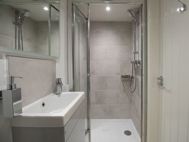 A bathroom with a shower area and sink with soap dispenser at Willowbrook Cottage in Litton Cheney