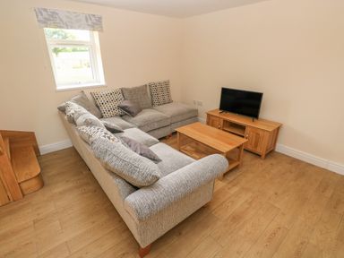 A living room with a corner sofa coffee table and television at Woodpecker Barn in Hensol near Pontyclun
