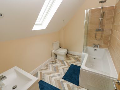 A bathroom with a bathtub shower toilet and sink at Woodpecker Barn in Hensol near Pontyclun