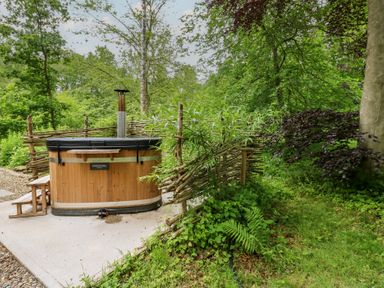 A hot tub surrounded by plants and a wooden fence at Bracken Fern in Eppleby