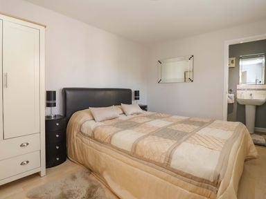 A bedroom with a bed and wardrobe at Cartwheel Cottage in Yearsley