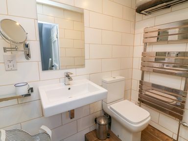 A bathroom with a sink toilet mirror and towel rack at 3 Elm Cottage in Carhampton