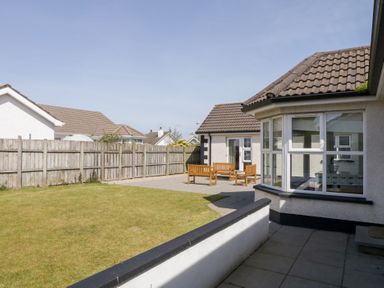 A garden with patio furniture and a lawn next to a house at SeaShells in Castlerock