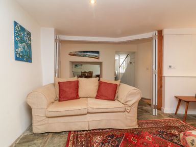 A living room with a sofa and dining table at Old Maids Cottage in Woolacombe