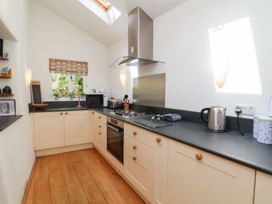 A kitchen with a stove and microwave at Old Maids Cottage in Woolacombe